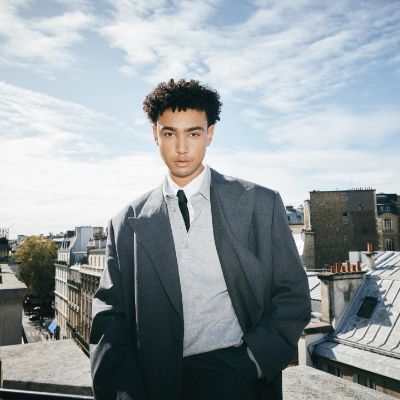 Archie Madekwe posted a picture that he took on a rooftop wearing a gray suit.